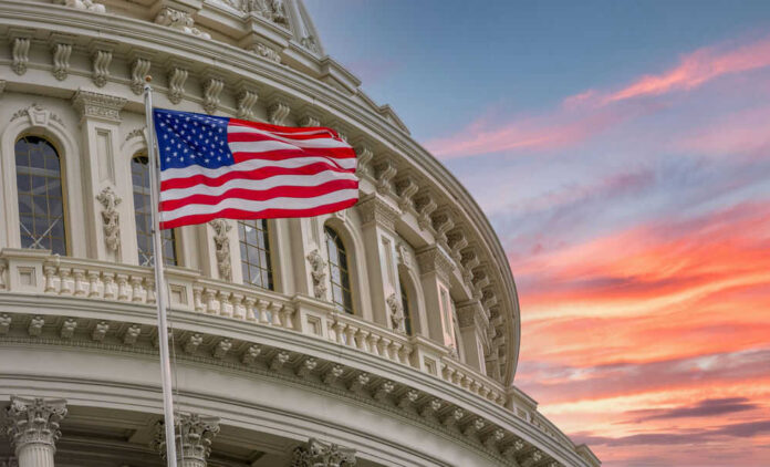 1814961938 American flag and Capitol building against colorful sky