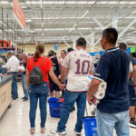 People shopping in a busy supermarket aisle
