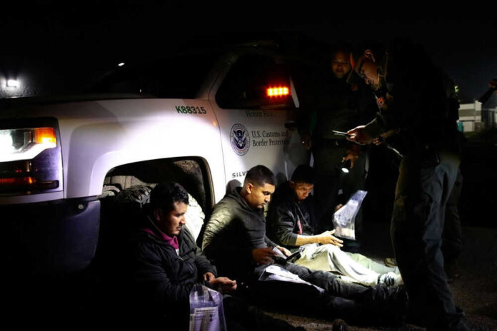 2444465937 Officials interacting with seated individuals at nighttime outdoors