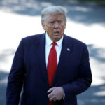 Man in suit with red tie walking outside