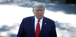 Man in suit with red tie walking outside