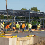 Construction workers laying concrete at building site