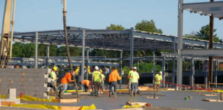 Construction workers laying concrete at building site