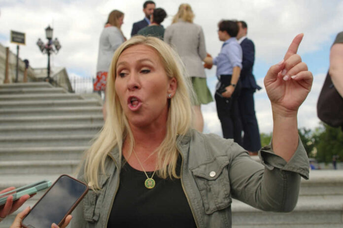 marjorie-taylor-greene-chairs-doge-subcommittee-shaping-maga-movement Woman gesturing and speaking outside on steps.