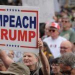 Trump SEIZES Venezuelan Oil — Senate FIGHTS Back A crowd at a protest holding a sign that says IMPEACH TRUMP
